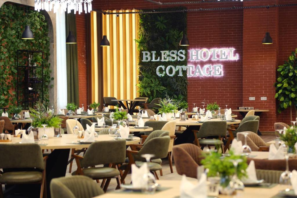 Bless Hotel Cottage restoranında yaşıllıqla bəzədilmiş yemək zalı