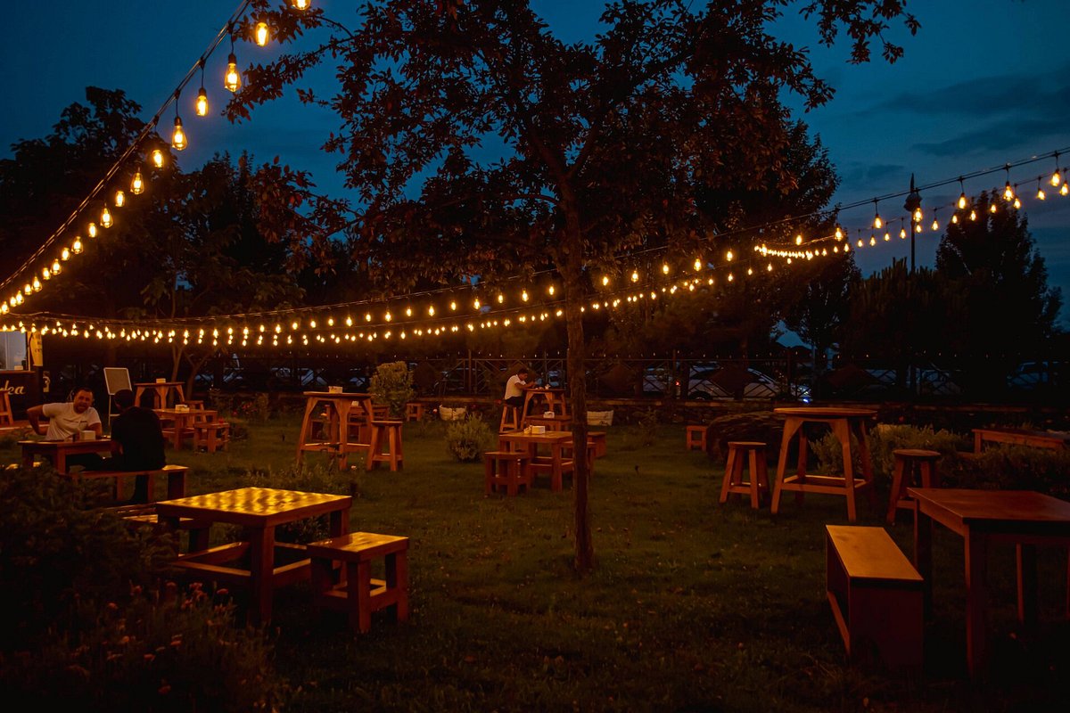Coffee Garden Gabala-nın axşam işıqları ilə bəzədilmiş açıq oturma sahəsi