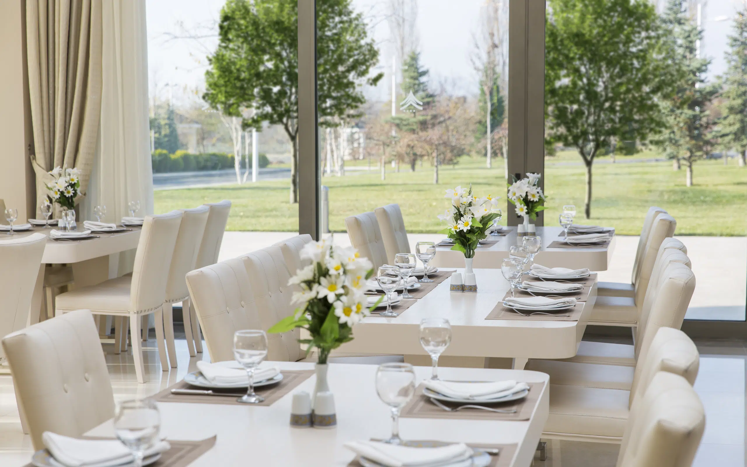 Garden Hotel restoranında bağa açılan pəncərələr qarşısında masalar