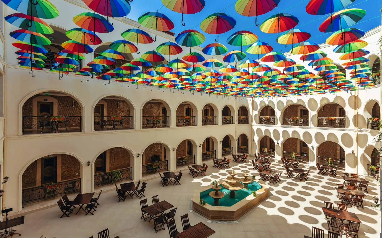 Karvansaray Hotel-də rəngli çətirlərlə bəzədilmiş Xalça restoranının həyəti